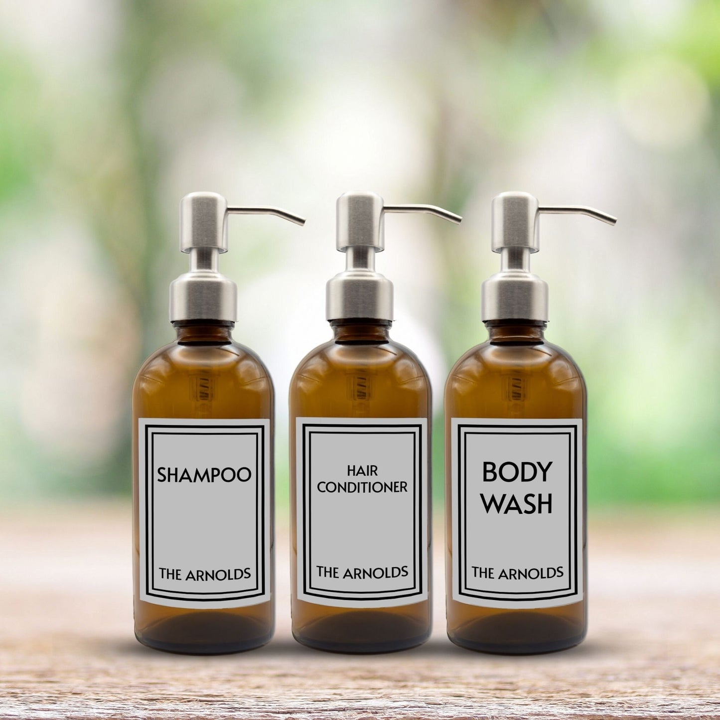 shampoo, hair conditioner and body wash set of three amber glass dispenser bottles for bathroom with custom labels and silver pumps