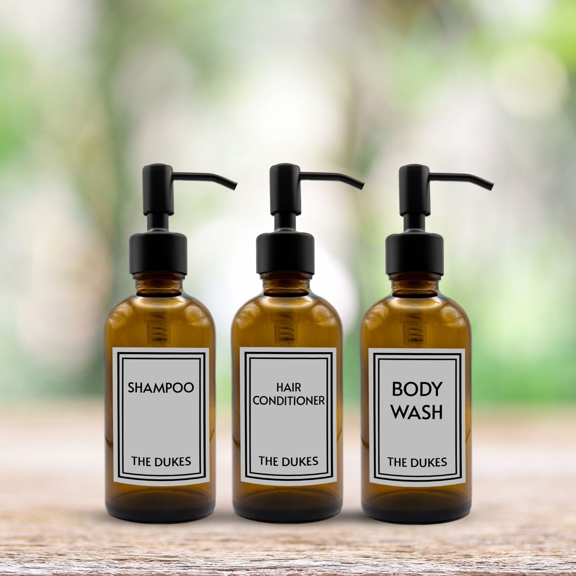 shampoo, hair conditioner and body wash set of three amber glass dispenser bottles for bathroom with custom labels and black pumps