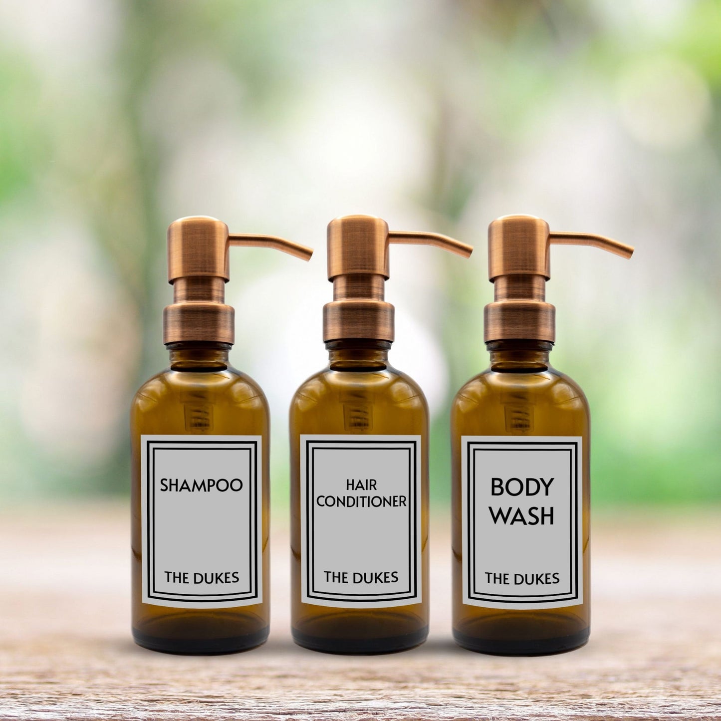 shampoo, hair conditioner and body wash set of three amber glass dispenser bottles for bathroom with custom labels and rose gold pumps