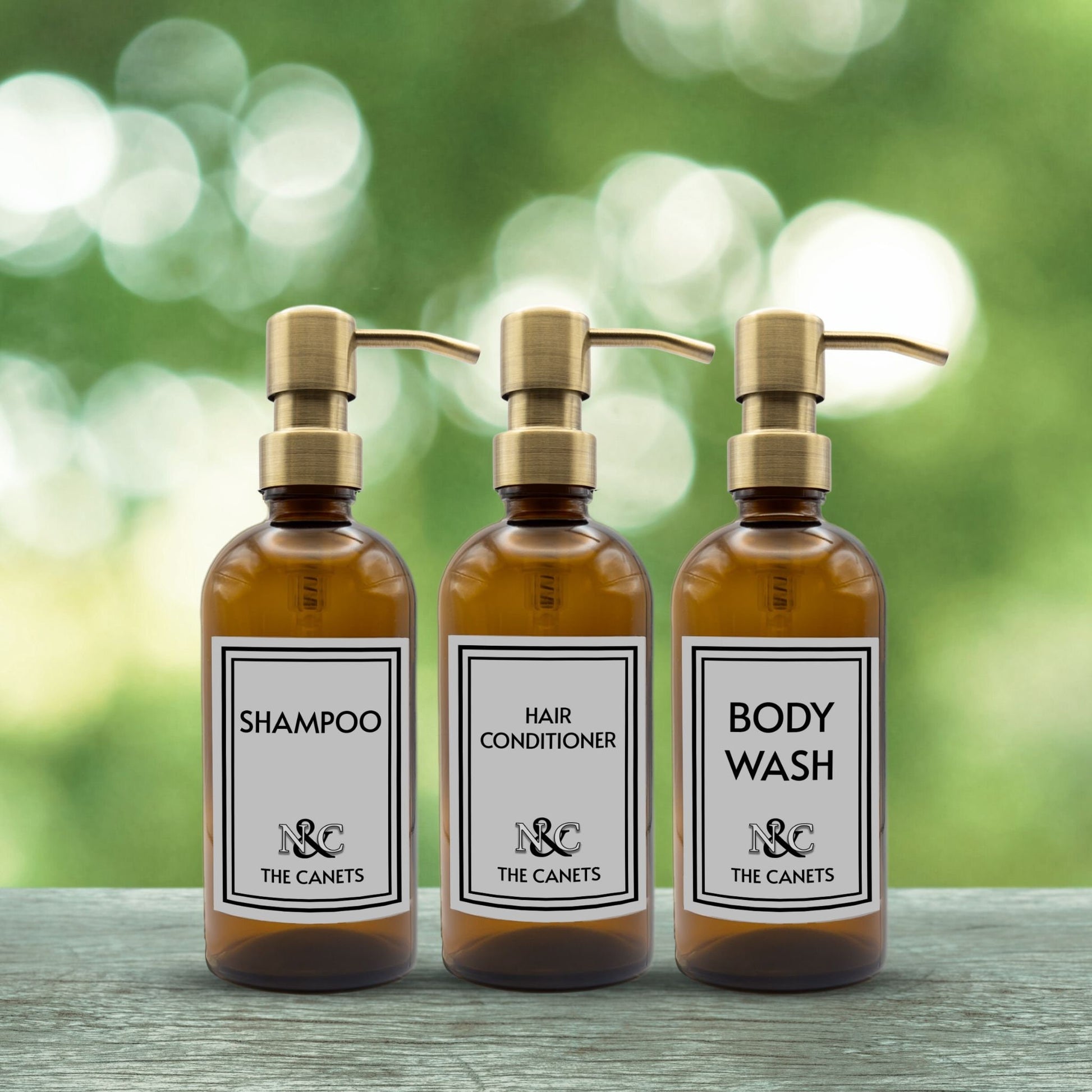 shampoo, hair conditioner and body wash set of three amber glass dispenser bottles for bathroom with custom monogrammed labels and gold pumps