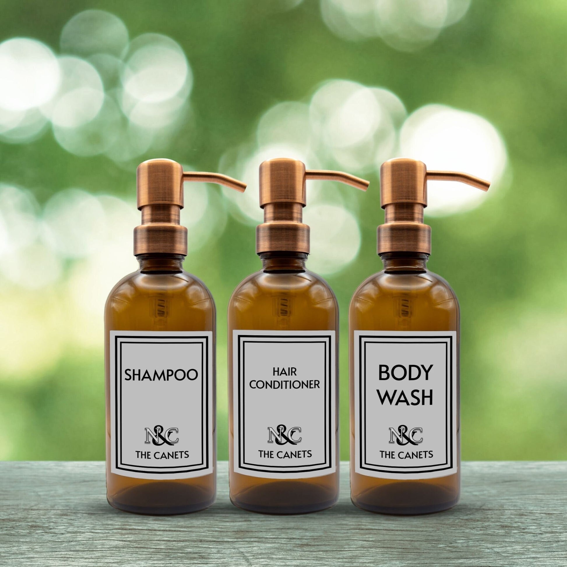 shampoo, hair conditioner and body wash set of three amber glass dispenser bottles for bathroom with custom monogrammed labels and rose gold pumps