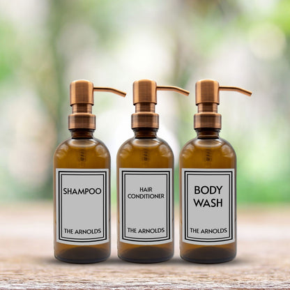 shampoo, hair conditioner and body wash set of three amber glass dispenser bottles for bathroom with custom labels and rose gold pumps